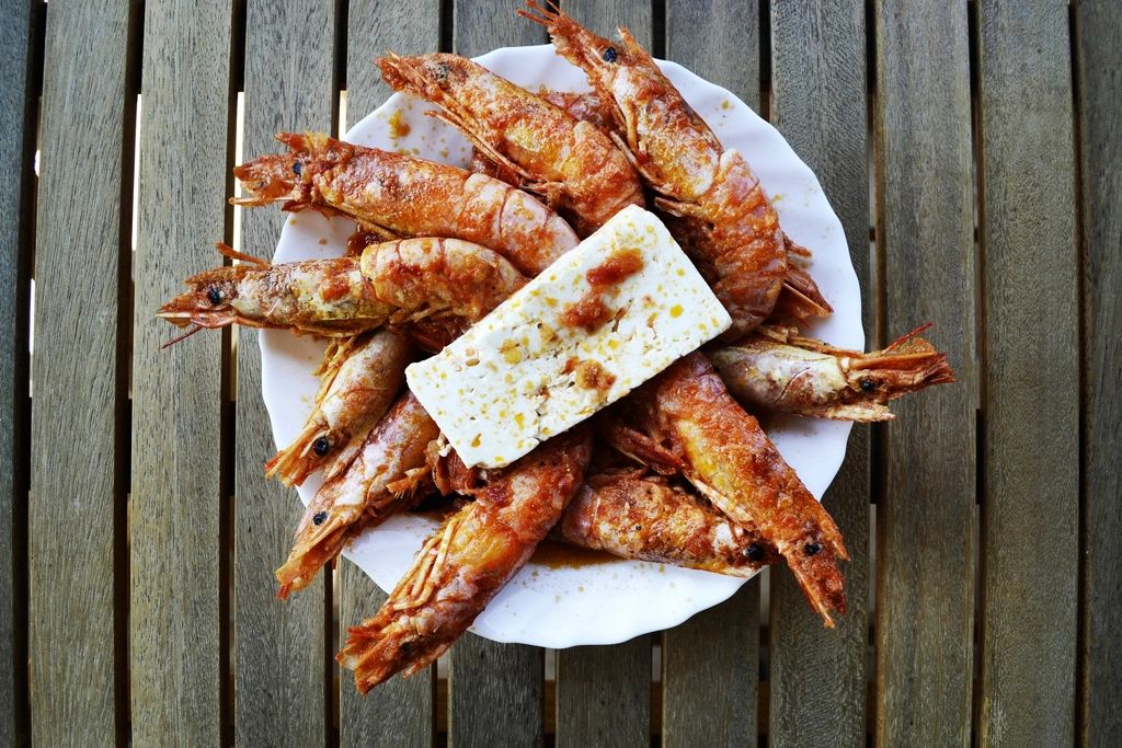 Des crevettes grillées à la feta, sur une table en bois