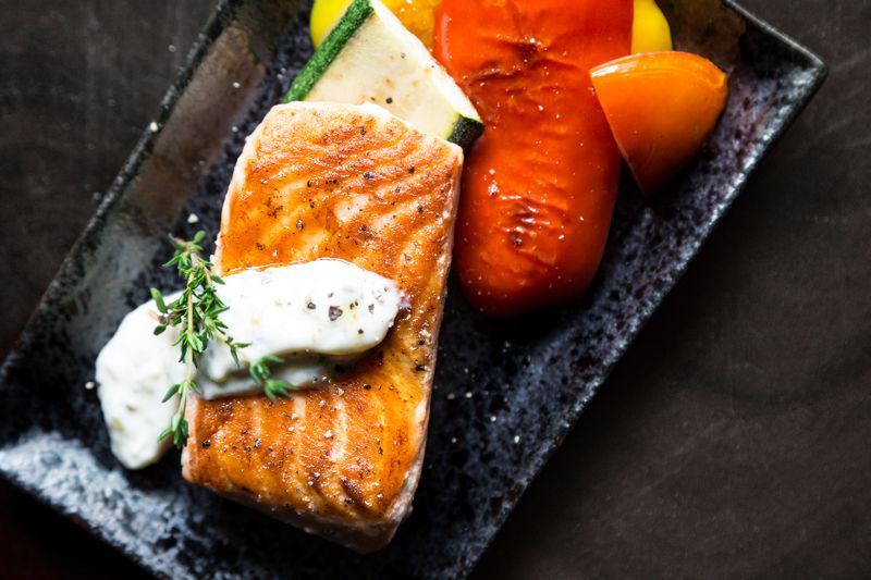 Un pavé de saumon grillé sur une ardoise, poivrons rôtis